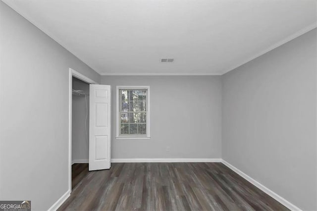 unfurnished bedroom with a closet, ornamental molding, and dark hardwood / wood-style flooring