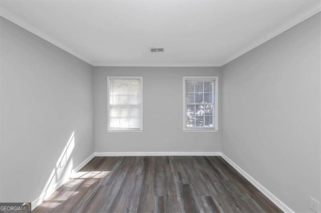 spare room featuring ornamental molding and dark hardwood / wood-style flooring