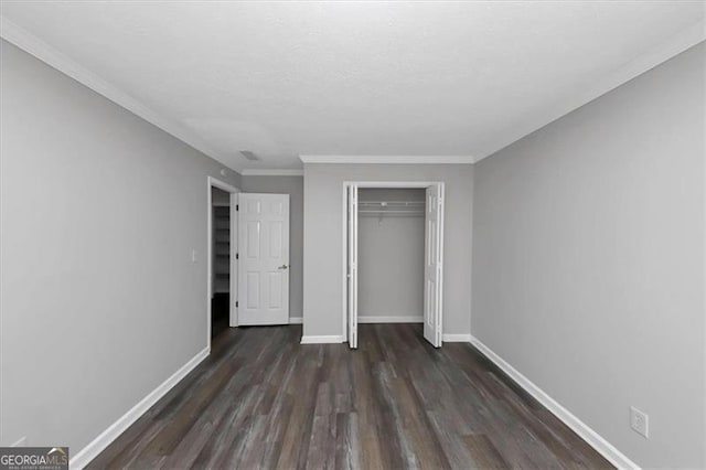 unfurnished bedroom with a closet, ornamental molding, and dark hardwood / wood-style floors