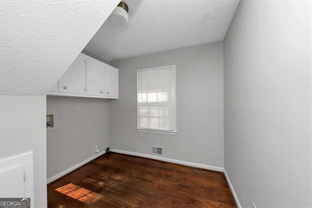 laundry area with cabinets, hookup for a washing machine, dark hardwood / wood-style floors, and a textured ceiling