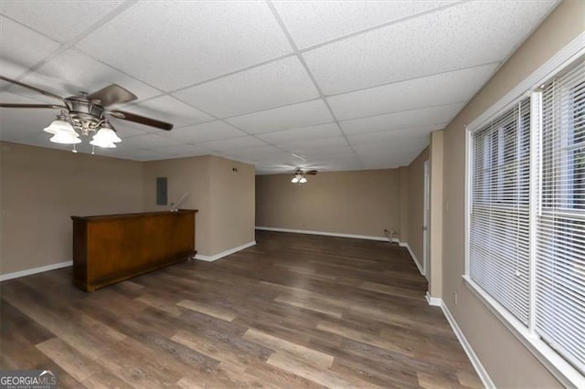 interior space with ceiling fan, electric panel, a drop ceiling, and dark hardwood / wood-style floors