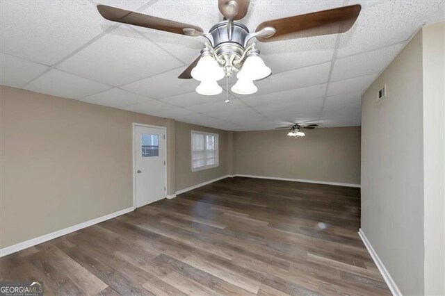 interior space with ceiling fan, dark hardwood / wood-style floors, and a paneled ceiling