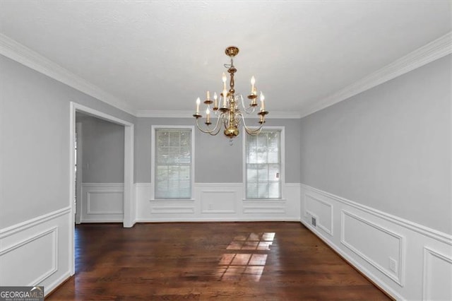 unfurnished dining area with a notable chandelier, ornamental molding, and dark hardwood / wood-style flooring