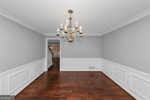 unfurnished dining area with an inviting chandelier, ornamental molding, and dark hardwood / wood-style floors