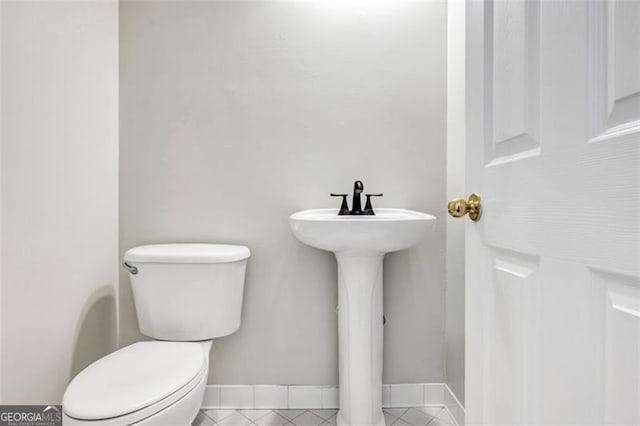 bathroom featuring sink, toilet, and tile patterned flooring