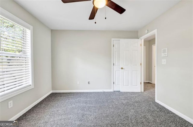 carpeted spare room featuring ceiling fan