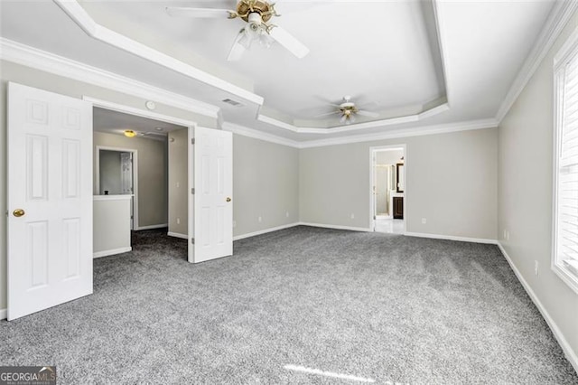 carpeted empty room featuring a tray ceiling, plenty of natural light, and ceiling fan