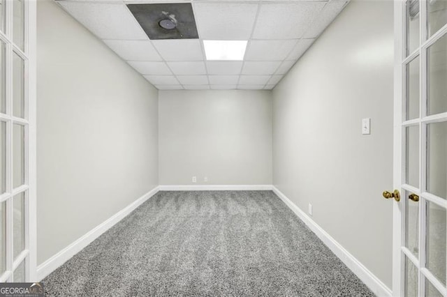 empty room with carpet flooring and a paneled ceiling