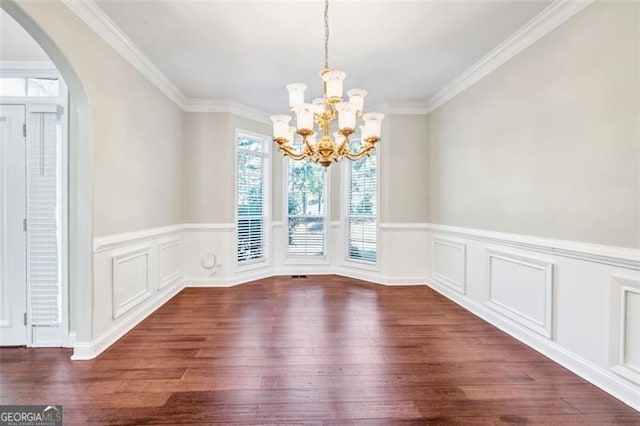 unfurnished dining area featuring ornamental molding, dark hardwood / wood-style flooring, and a chandelier