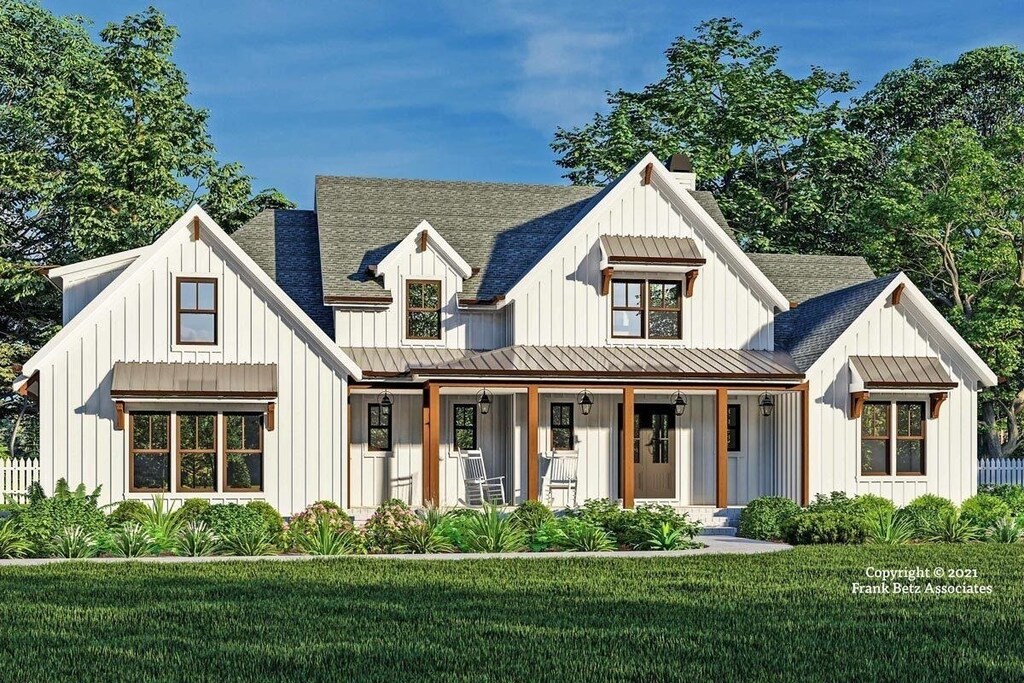 modern farmhouse style home featuring covered porch and a front yard