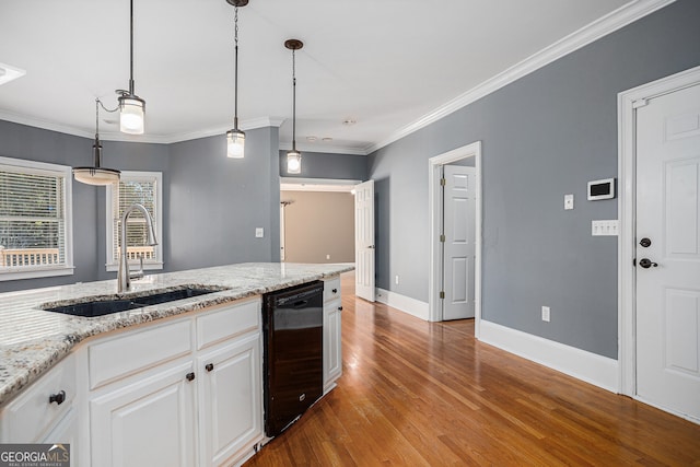 kitchen with light hardwood / wood-style flooring, ornamental molding, sink, pendant lighting, and white cabinetry