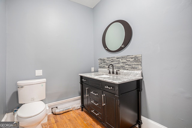 bathroom featuring toilet, hardwood / wood-style floors, and vanity