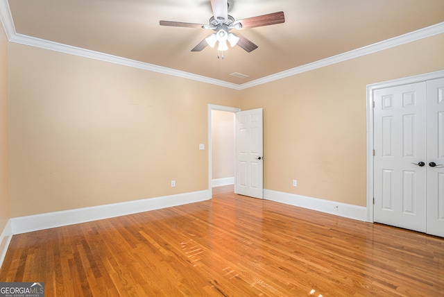 unfurnished bedroom featuring ceiling fan, crown molding, and hardwood / wood-style floors