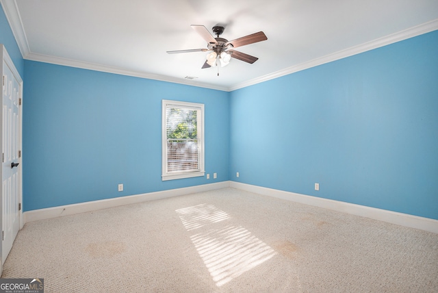 empty room featuring crown molding, carpet flooring, and ceiling fan