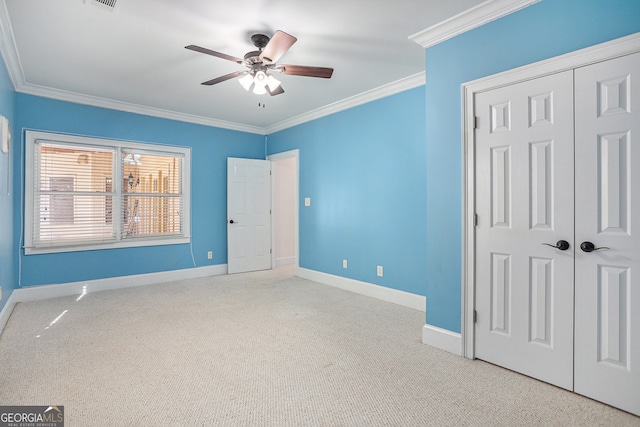 unfurnished bedroom with ornamental molding, light colored carpet, a closet, and ceiling fan