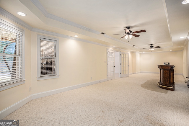 spare room with ornamental molding, carpet floors, a tray ceiling, and ceiling fan