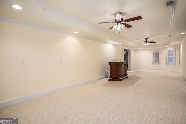 basement with ornamental molding, bar, carpet flooring, and ceiling fan