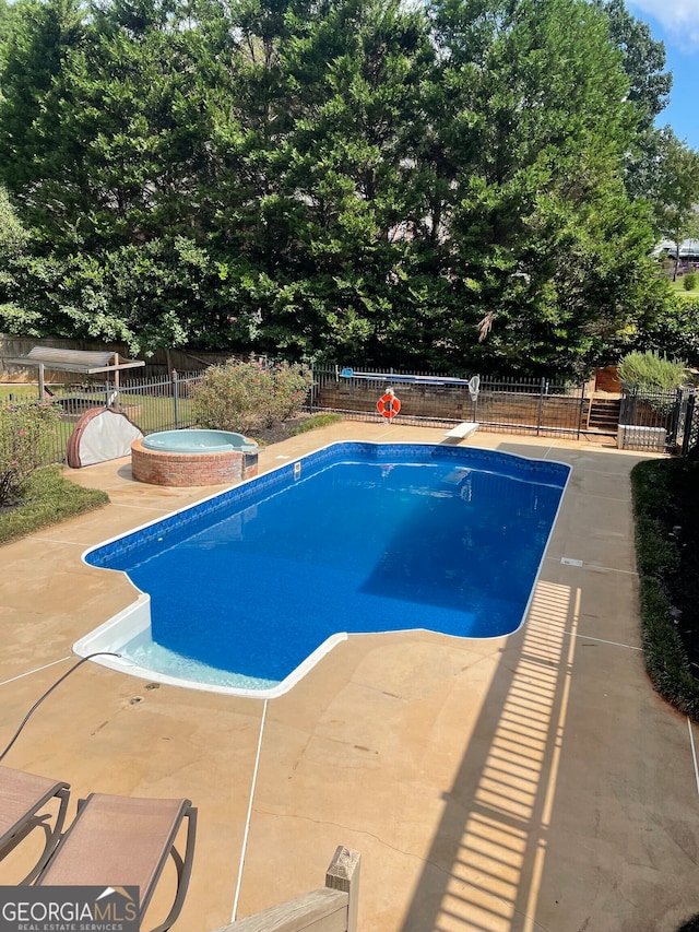 view of swimming pool featuring a patio area and an in ground hot tub