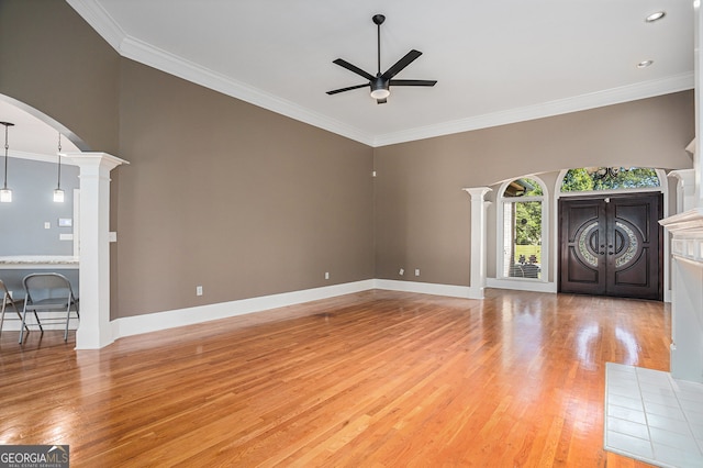 unfurnished living room with light hardwood / wood-style flooring, ornamental molding, and ornate columns