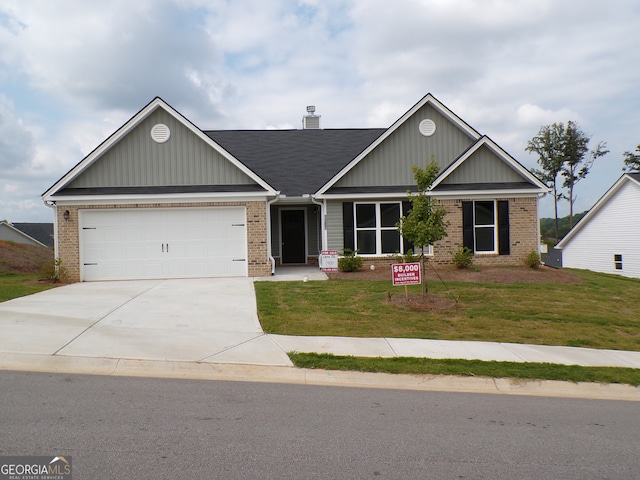 craftsman inspired home featuring a front yard and a garage