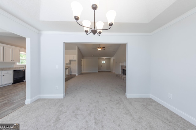 unfurnished dining area with crown molding, light carpet, a brick fireplace, and ceiling fan with notable chandelier