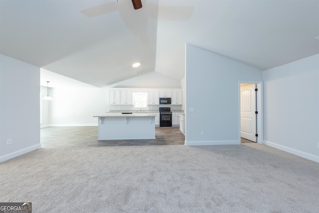 unfurnished living room featuring light carpet, lofted ceiling, and ceiling fan