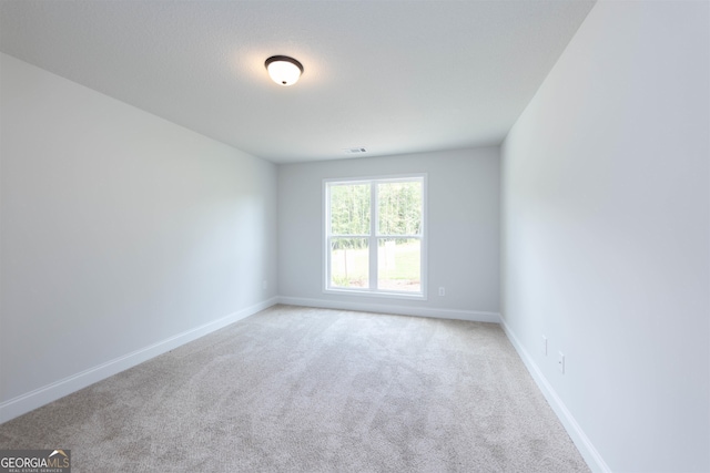 unfurnished room featuring light colored carpet