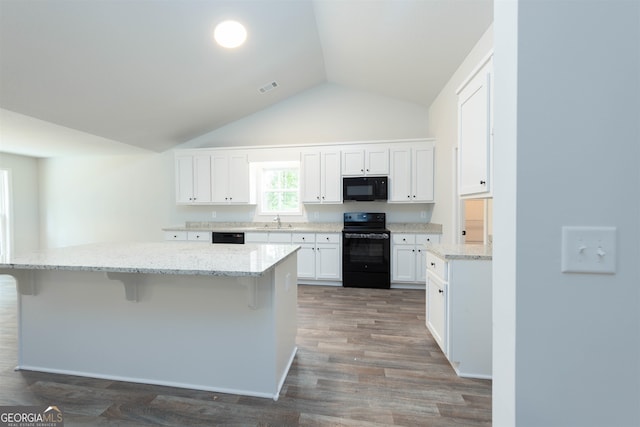 kitchen featuring dark hardwood / wood-style floors, sink, black appliances, vaulted ceiling, and white cabinets