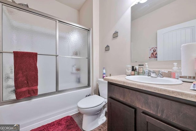 full bathroom with vanity, shower / bath combination with glass door, and toilet