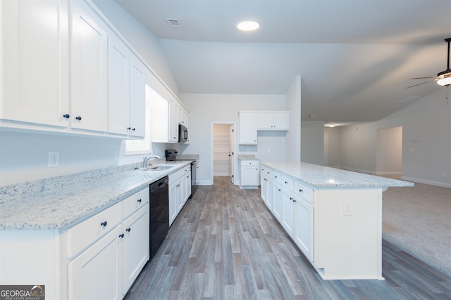 kitchen featuring stainless steel appliances, light wood-type flooring, a kitchen island, and white cabinets