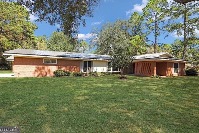 back of house with a lawn and brick siding