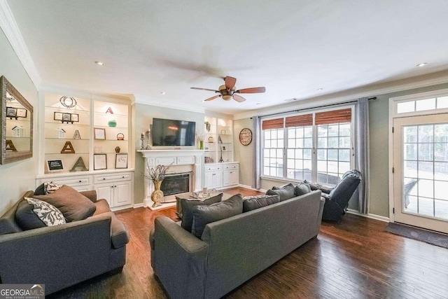 living room featuring built in shelves, ornamental molding, a high end fireplace, and dark hardwood / wood-style flooring