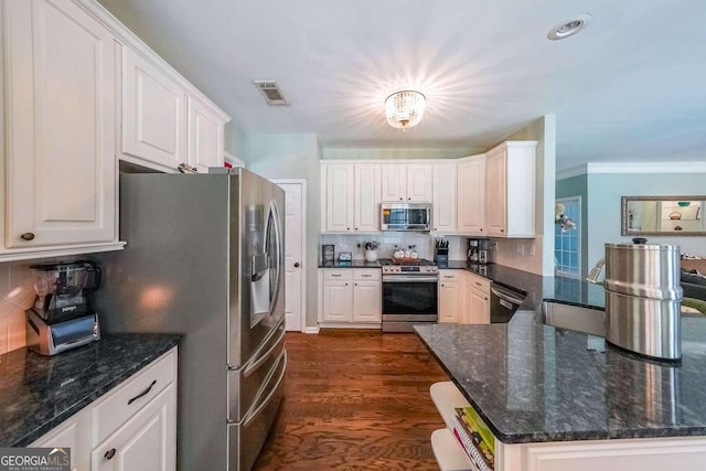 kitchen with white cabinetry, appliances with stainless steel finishes, dark hardwood / wood-style flooring, and decorative backsplash