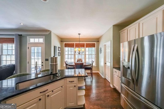 kitchen featuring dark hardwood / wood-style floors, a healthy amount of sunlight, decorative light fixtures, and stainless steel fridge with ice dispenser