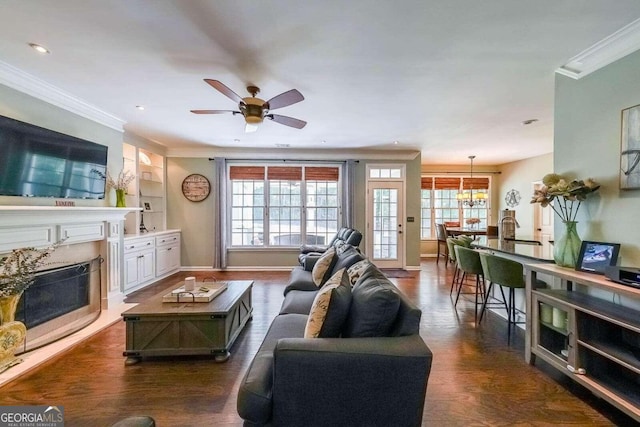 living room with ornamental molding, dark hardwood / wood-style flooring, a fireplace, and built in shelves