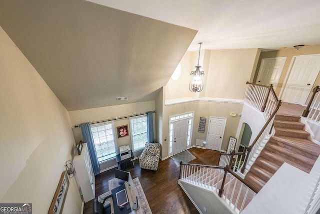 foyer featuring a notable chandelier, a towering ceiling, and dark hardwood / wood-style floors