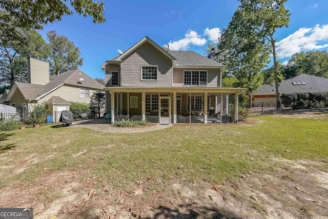 back of house with a sunroom and a lawn