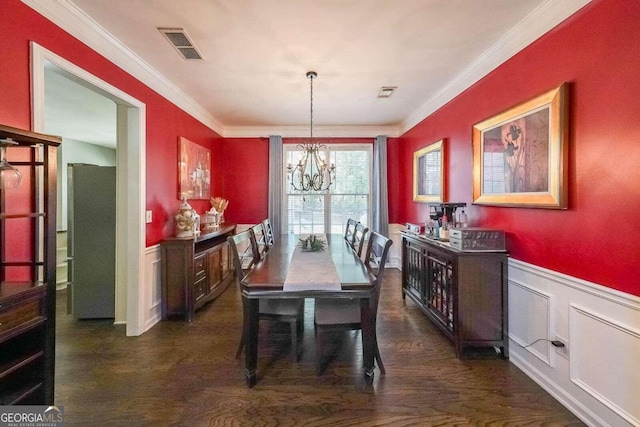 dining room featuring an inviting chandelier, dark hardwood / wood-style flooring, and ornamental molding