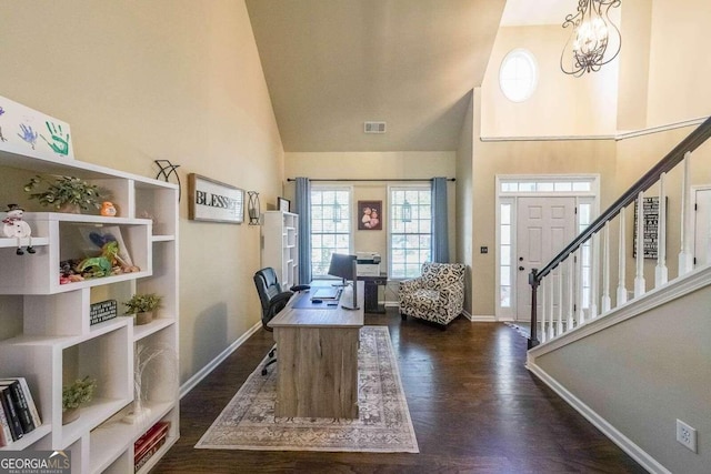 office space featuring a high ceiling, a notable chandelier, and dark hardwood / wood-style flooring