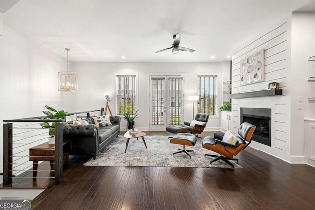 living room with dark wood-type flooring and ceiling fan