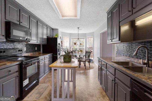 kitchen featuring sink, black appliances, decorative backsplash, and a textured ceiling