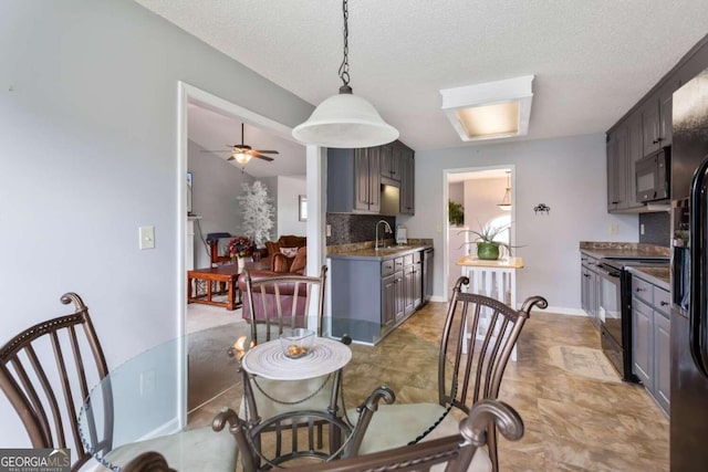 dining area featuring a textured ceiling, sink, and ceiling fan