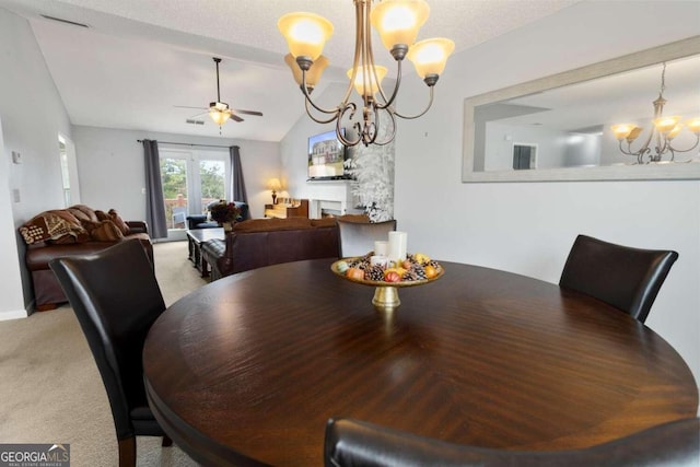 carpeted dining area featuring lofted ceiling, french doors, a textured ceiling, and ceiling fan with notable chandelier