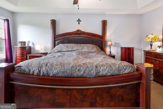 carpeted bedroom with ceiling fan and a textured ceiling