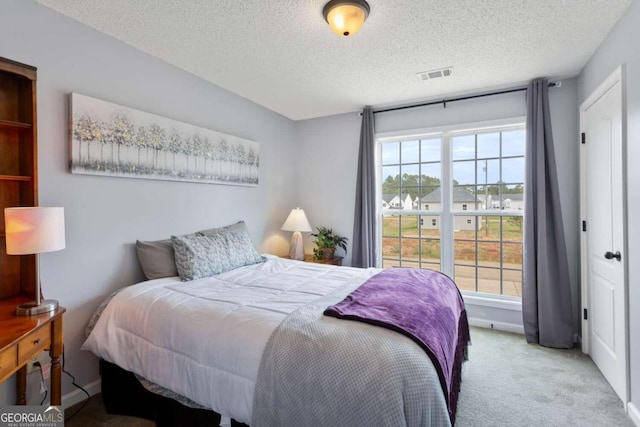 carpeted bedroom featuring a textured ceiling