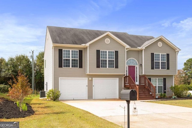 raised ranch with a front yard, central AC, and a garage