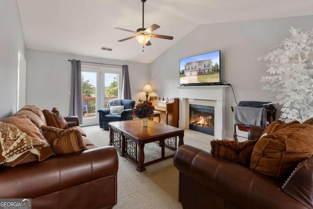 living room with ceiling fan, vaulted ceiling, and light colored carpet