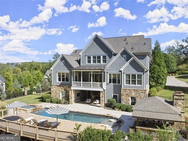 back of property featuring a balcony and a patio