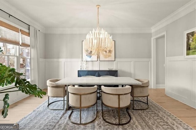 dining room featuring ornamental molding, light hardwood / wood-style flooring, and a chandelier