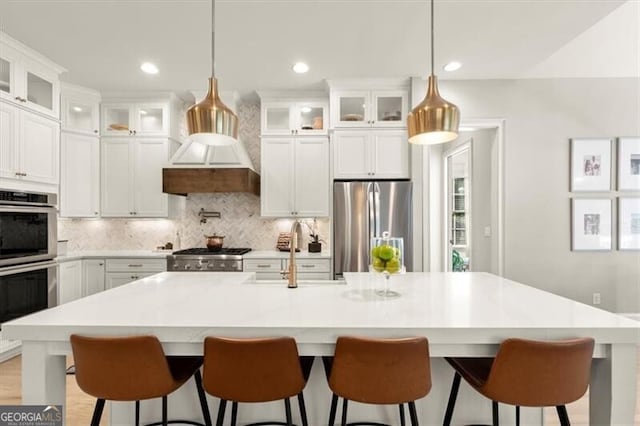 kitchen featuring appliances with stainless steel finishes, sink, and a kitchen island with sink